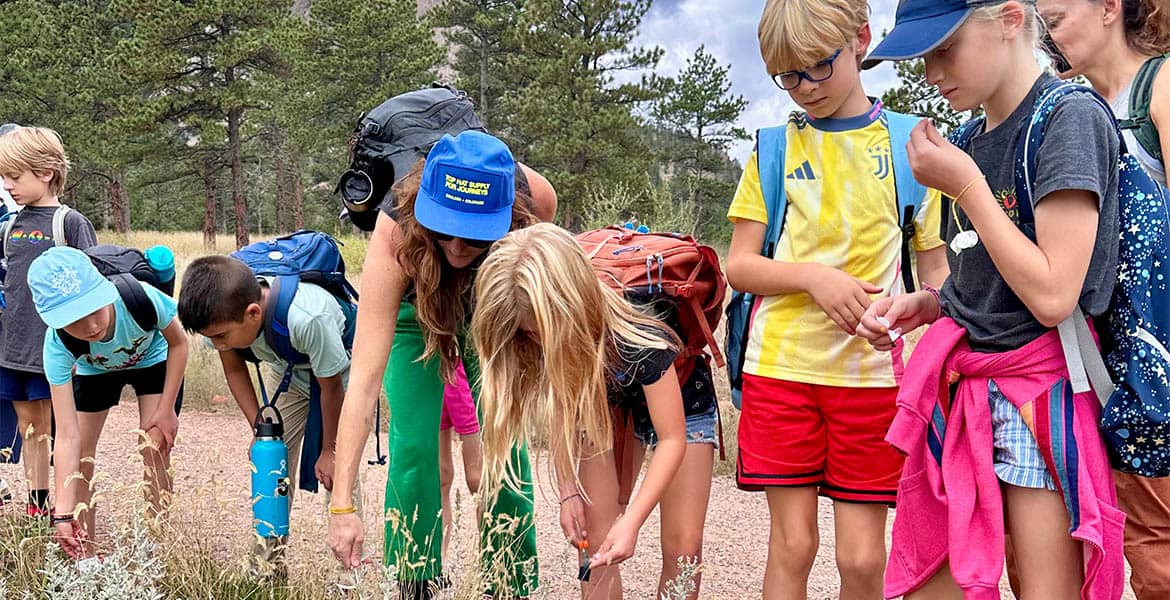 Schoolchildren are working on a science project outdoors.